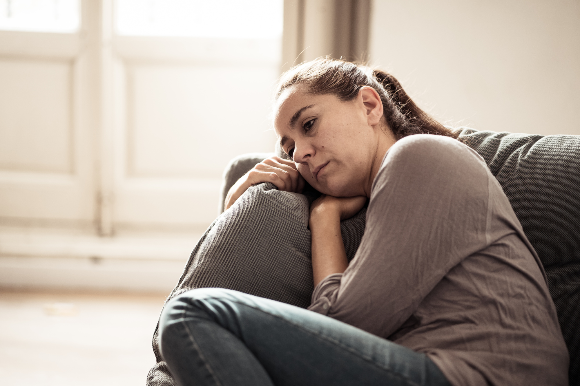 Woman looking anxious while sitting alone at home