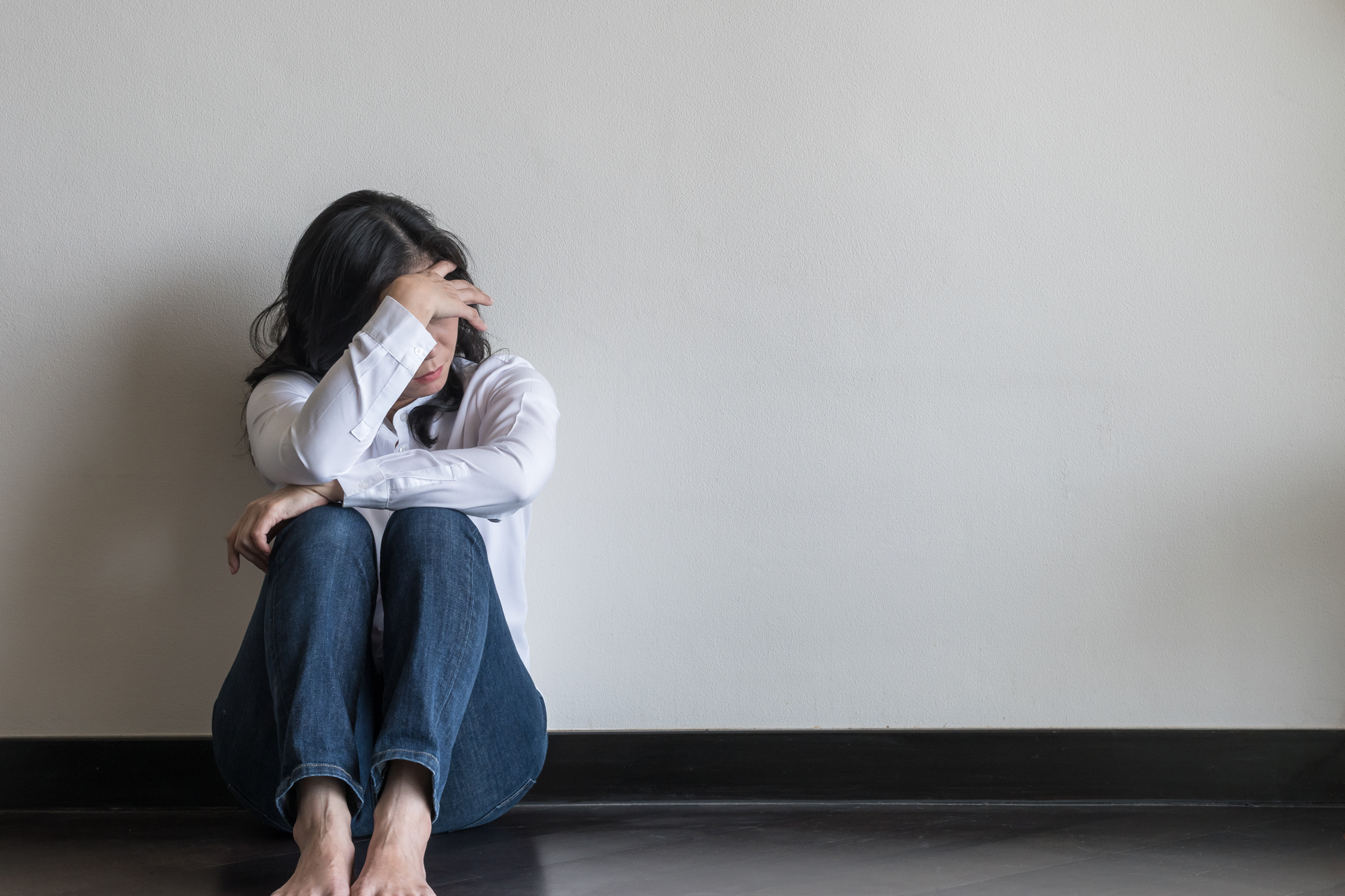 Tired mother sitting alone at home feeling overwhelmed by daily stress