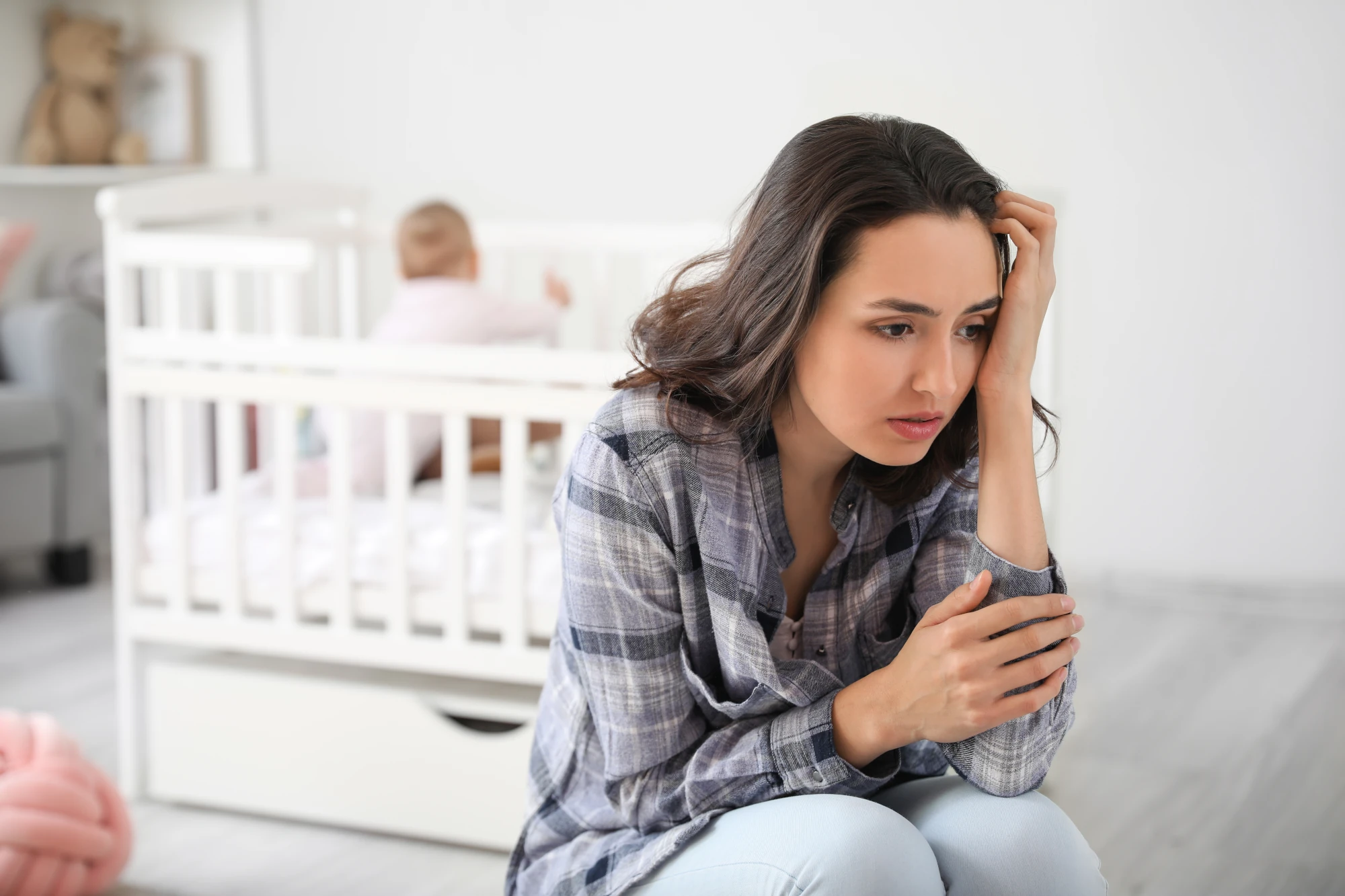 Tired new mother at home with her baby during the postpartum period
