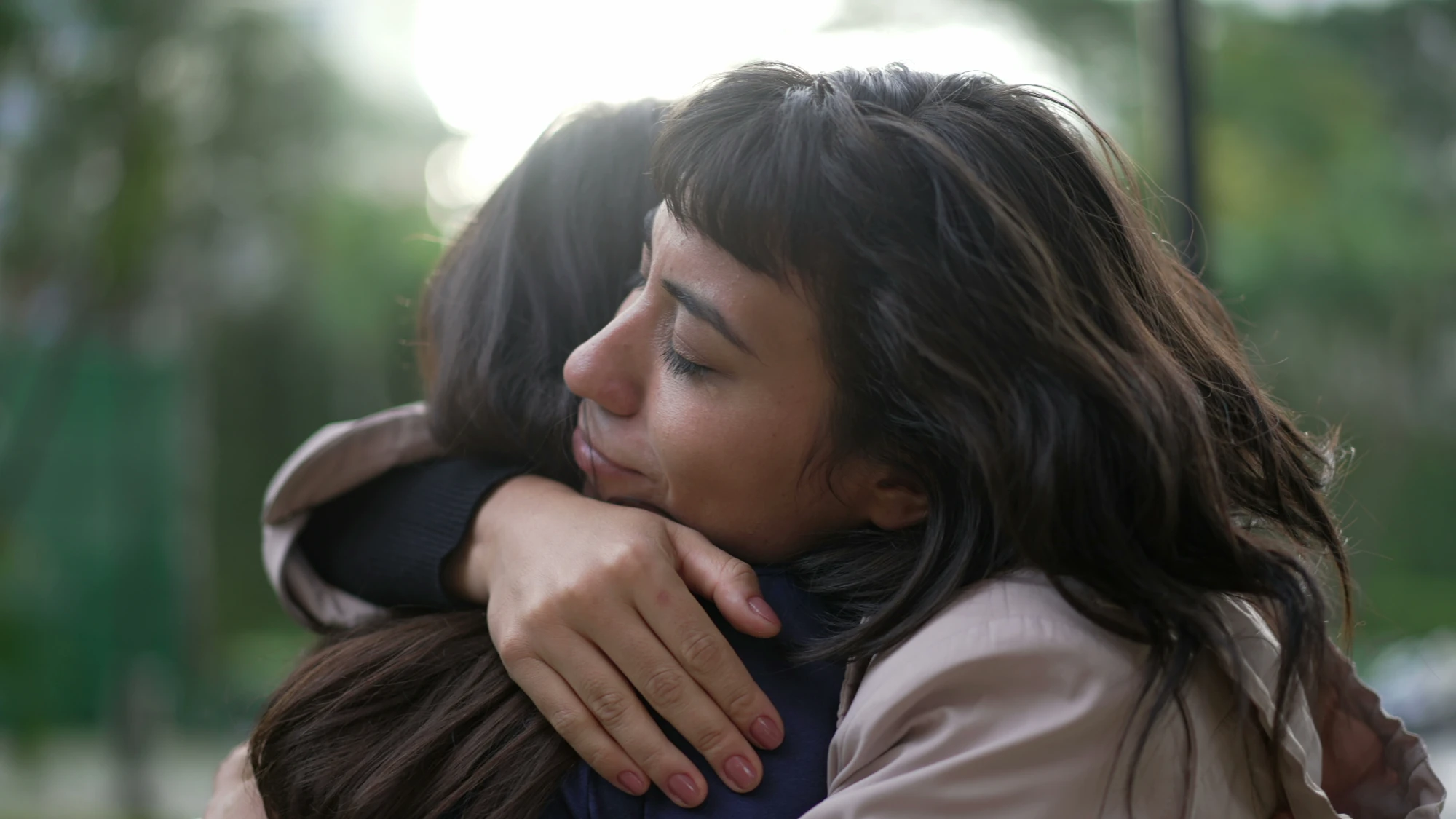 Woman hugging a family member during an emotional conversation.
