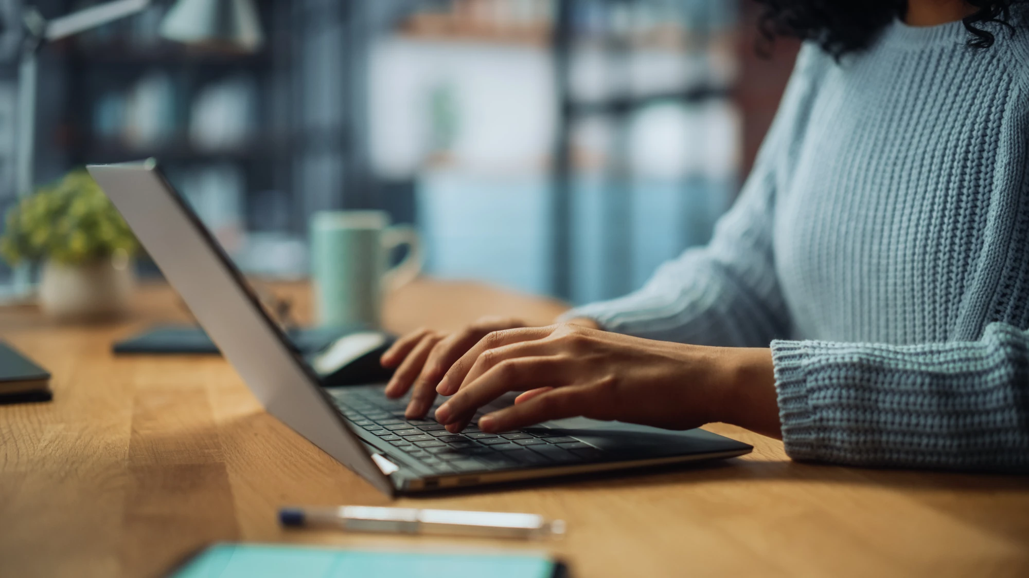 Woman typing on a laptop at a desk