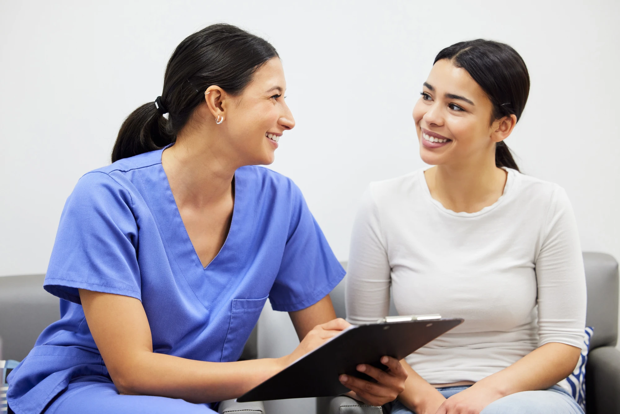 A woman talks with a healthcare provider during an appointment in a medical office.