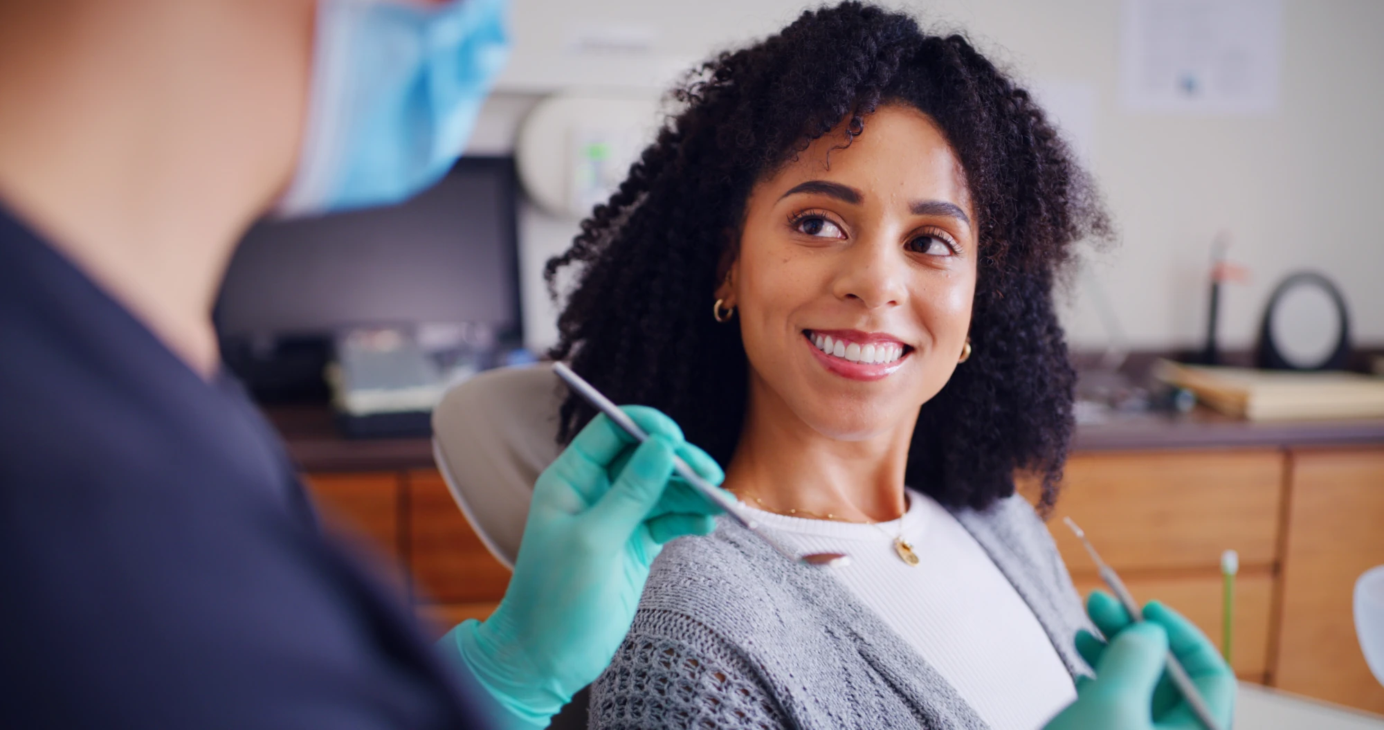 A woman sits in a dental chair during a checkup.