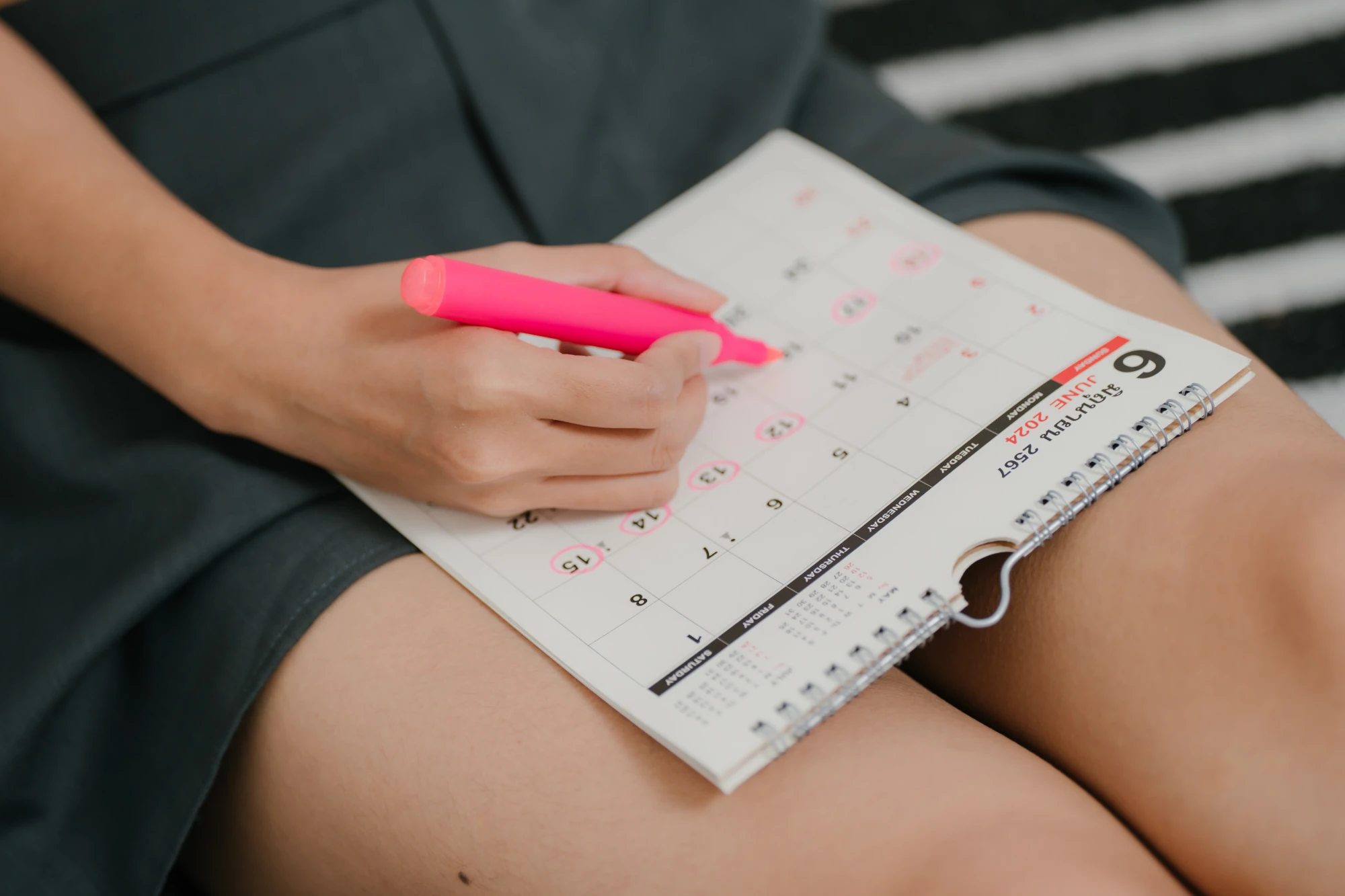A calendar with several dates marked, lying on a table.
