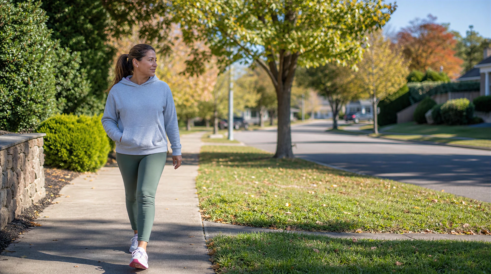 A woman walks along an outdoor path on a sunny day.
